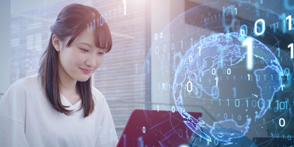 A young woman sitting in front of a laptop, with faded digital numbering overlaying a digital representation of earth.